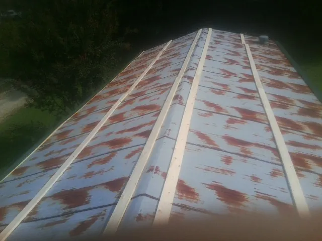 Rusted metal roof panels with new wood purlins before replacement — Storm Damage Roof Repair in Elkwood by Roofing Brothers