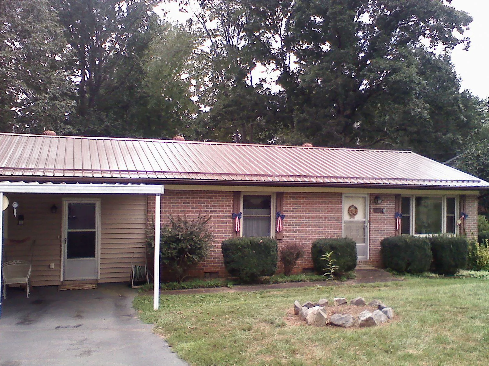 Bronze metal roof and carport on a brick ranch home — Roof Repair work by our crew in Elkwood